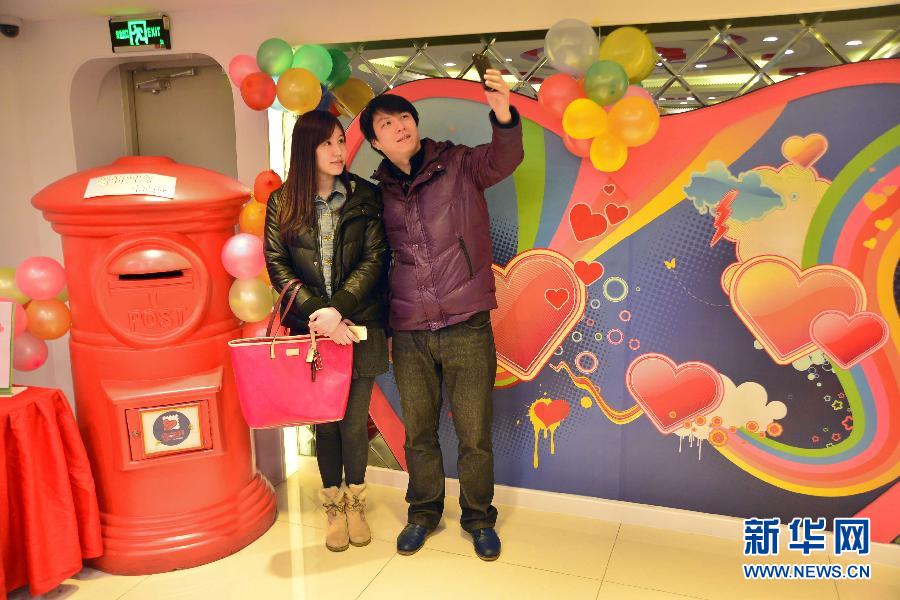 上海 爱情/2月14日，上海市民孙先生和汪小姐在“爱情邮局”内自拍合影。