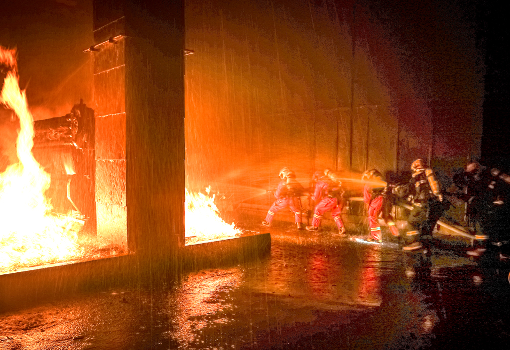 在封闭的火灾现场,消防员合力冲锋打压火势.